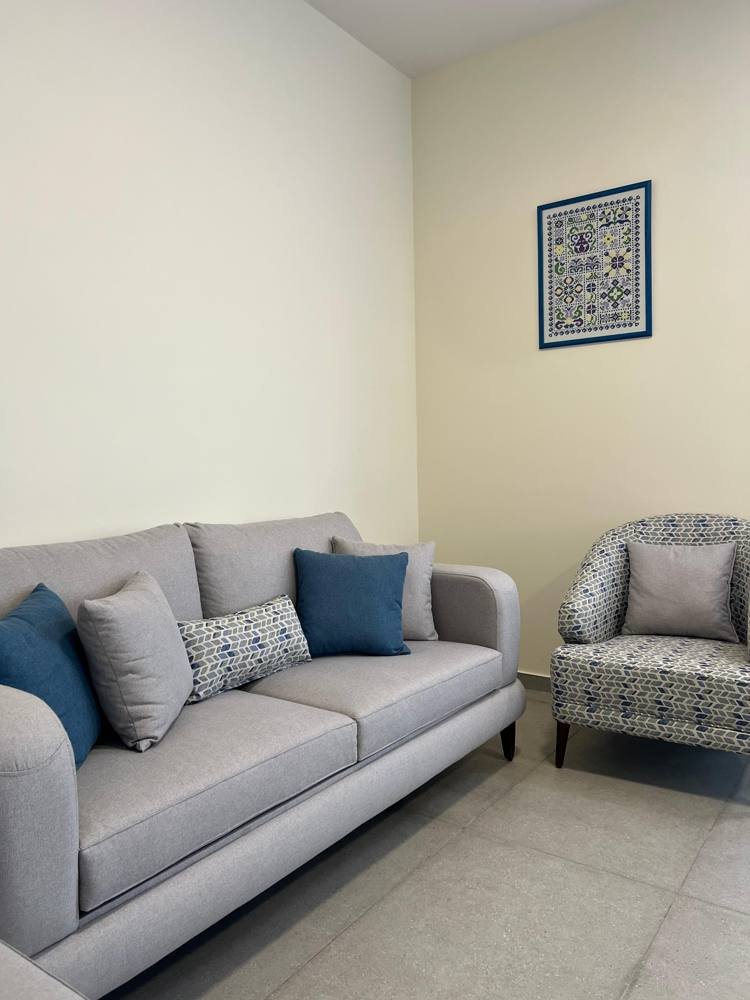 The lounge with its sofa, patterned armchair and blue cushions