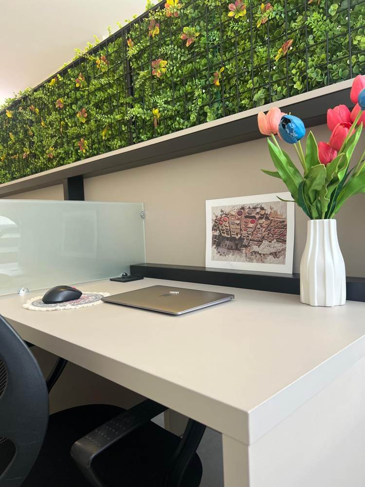 A desk with tulips beside the green wall